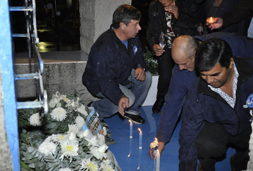 Regner, Gallardo y Acosta dejan velas encendidas frente al monumento.